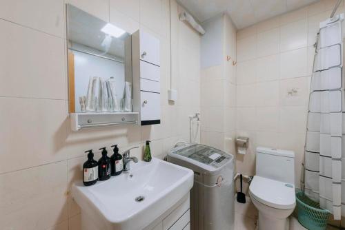 a white bathroom with a sink and a toilet at Xi’an Beilin·Moslem Street (Huimin Jie)· Locals Apartment 00174500 in Xi'an