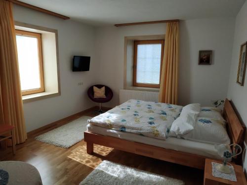 a bedroom with a bed and two windows at Ferienwohnung Sailer in Fügen