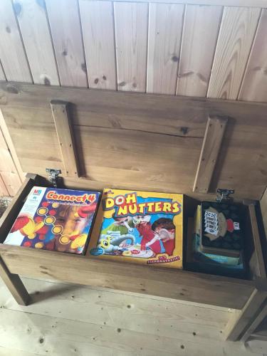 a wooden bench with some games on it at Cosy Countryside Log Cabin in Kilkenny