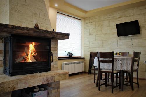 ein Wohnzimmer mit einem Kamin und einem Tisch mit Stühlen in der Unterkunft Rupchini Houses in Bansko