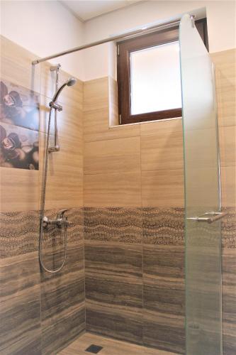 une salle de bain avec douche et porte en verre dans l'établissement Rupchini Houses, à Bansko