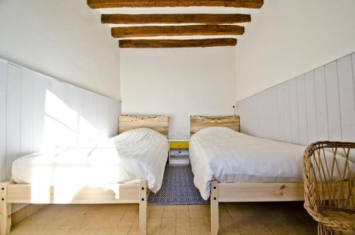 two beds in a small room with at La chaumière des deux amants in Vatteville