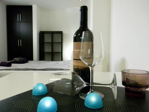 a bottle of wine and a glass on a table at Apartments Luka in Kragujevac