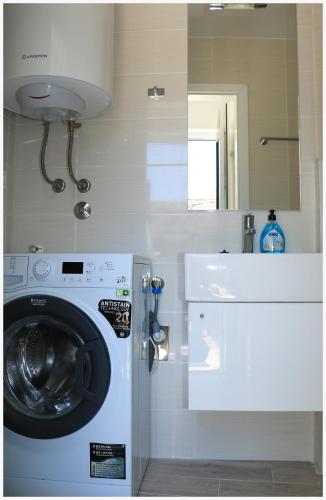 a laundry room with a washing machine and a sink at Holiday Home Ante in Primošten