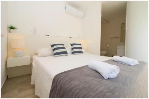 two beds in a white room with towels on them at Holiday Home Ante in Primošten