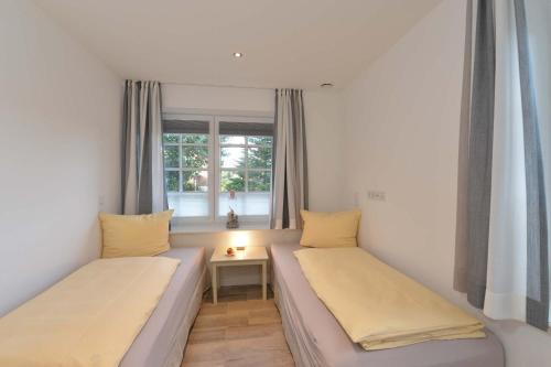 two beds in a small room with a window at Strandgut 3 in Westerland (Sylt)
