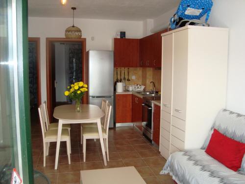 a small kitchen with a table and a refrigerator at Apartment for Family in Kriopigi