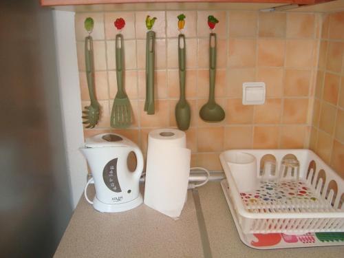 a kitchen counter with utensils hanging on a wall at Apartment for Family in Kriopigi