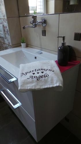 a bathroom sink with a towel that says congratulationsinteger at Apartament Angelo in Sosnowiec