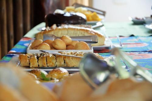 a table topped with different types of food on plates at Pousada Das Roseiras in Barra Grande
