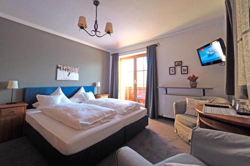 a bedroom with a large bed and a living room at Pension Hinterseer in Kitzbühel