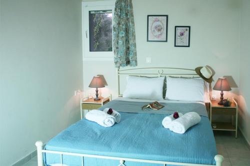 a bedroom with a blue bed with towels on it at Aeraki in Lefkada