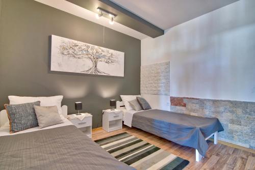 a bedroom with two beds and a tree painting on the wall at Meerblick Ferienhaus Julian nahe Rovinj in Rovinj