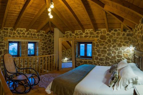 ein Schlafzimmer mit einem Bett und einem Stuhl in einem Zimmer in der Unterkunft Anotopos in Ano Trikala