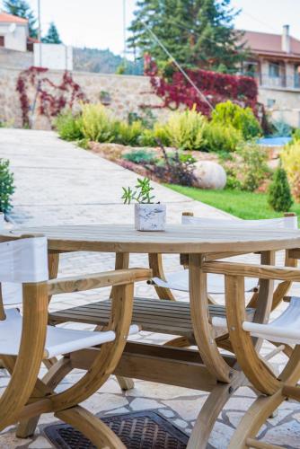 a wooden picnic table with a potted plant on it at Anotopos in Ano Trikala