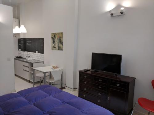 una sala de estar con una gran cama azul y un escritorio en La mejor ubicación en Buenos Aires