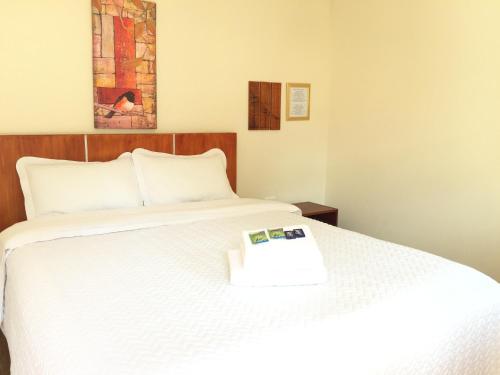 a bedroom with a white bed with a book on it at Quito Terrace in Quito