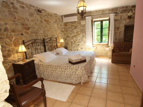 a bedroom with a bed in a room with stone walls at Casa Torre Vella in Bueu