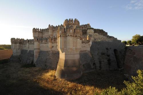 an old castle sitting in the middle of a field at Señorío de los Fonseca in Coca