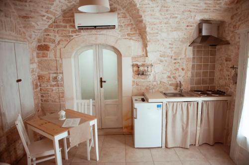 une cuisine avec une table et un réfrigérateur blanc dans l'établissement Exclusive Apartments, à Martina Franca