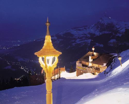a yellow street light on top of a snow covered mountain at Hocheckhuette On Top of the Kitzbuehel Hahnenkamm Mountain in Kitzbühel