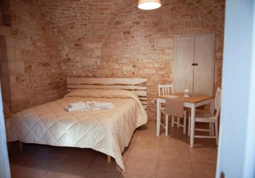 une chambre avec un lit, une table et des chaises dans l'établissement Exclusive Apartments, à Martina Franca
