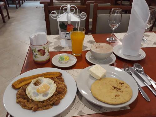 a table with a plate of food with eggs and beans at Hotel Del Parque in La Ceja