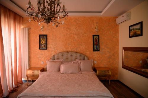una camera da letto con un letto grande con un lampadario di DREAM Party VILLA a Bucarest