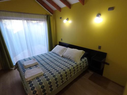 ein Schlafzimmer mit einem Bett und einem Fenster mit Handtüchern darauf in der Unterkunft Rio Lingue in Valdivia