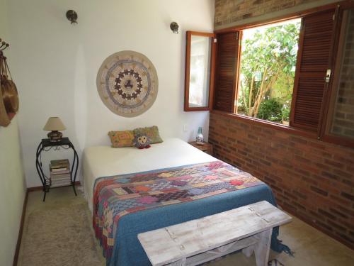 a bedroom with a bed and a window at Casa de vidro in Petrópolis