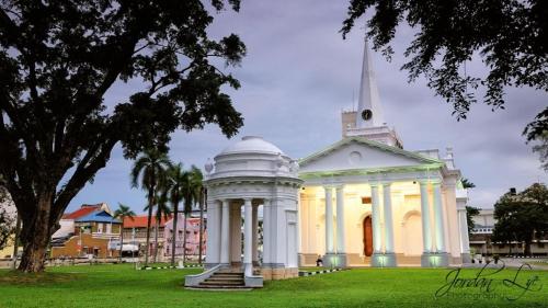 a white building with a steeple in a park at Fastbook Bendera Home 8 & 10pax in Ayer Itam