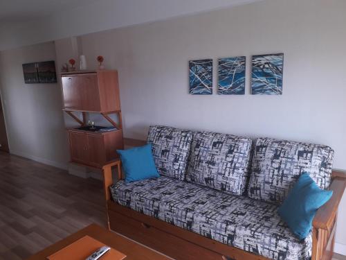 a living room with a couch with blue pillows at ESPECTACULAR Alem 5007 piso 7 in Mar del Plata