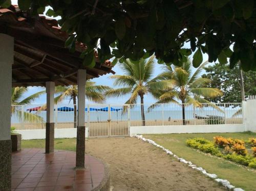 a pathway with palm trees and the beach in the background at Espectacular cabaña en Coveñas - Sucre, Frente al mar!!! in Coveñas
