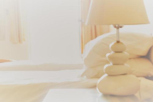 a white lamp sitting on a table next to a bed at Kololi Beach Resort in Kololi