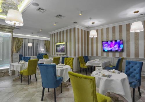 a restaurant with tables and chairs and a tv at FENIX TOWN in Vinnytsya