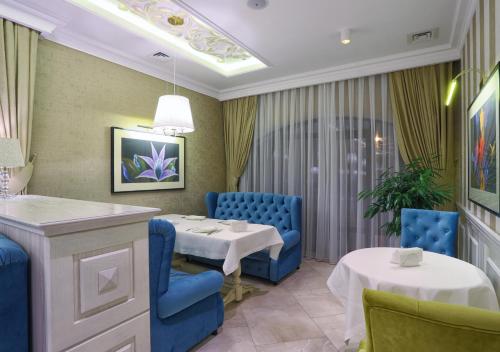 a dining room with blue chairs and a table and a table and chairs at FENIX TOWN in Vinnytsya