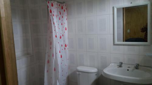 un bagno con tenda doccia con cuori sopra di Cabaña tablaqui a El Quisco