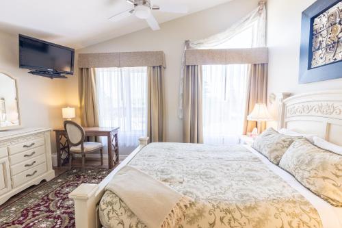 1 dormitorio con 1 cama, escritorio y TV en Lakeshore Inn en Cold Lake