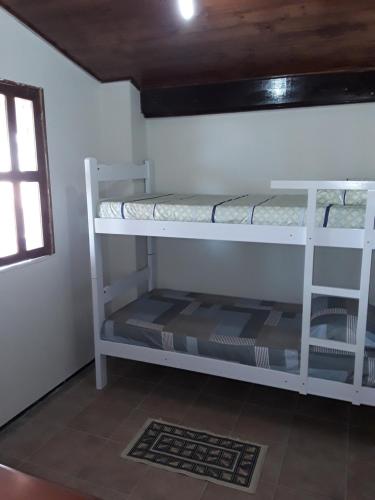 two bunk beds in a room with a window at Villa Orazio Prainha in Prainha