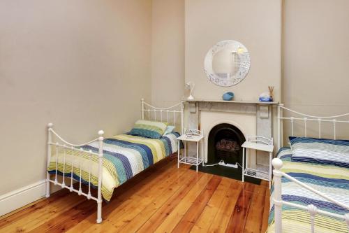 a bedroom with two beds and a fireplace at Maeville Cottage in Broken Hill