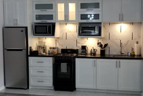 a kitchen with white cabinets and black appliances at Millsborough B&B in Billy Dun