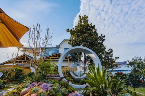 a garden with a sculpture in front of a building at Su Xin Resort Inn in Zhangjiajie