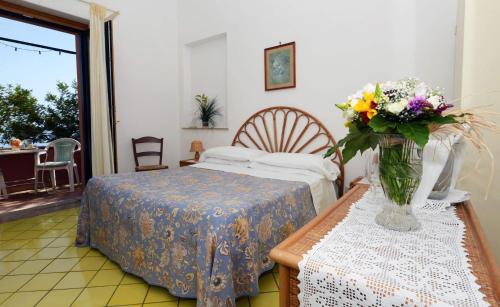 a hotel room with a bed, table and chairs at Villa Maria Antonietta in Positano