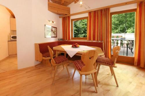 a dining room with a table and some chairs at Ferienwohnungen Haaser in Maurach