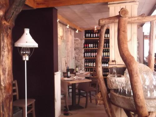 una sala da pranzo con tavolo e una mensola di bottiglie di vino di Locanda Poncini a Maggia