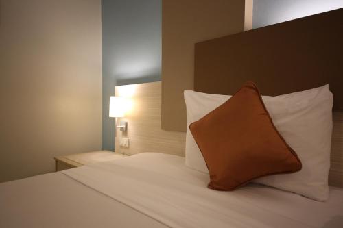a bedroom with a bed with a pillow on it at Sunshine Vista Hotel in Pattaya Central