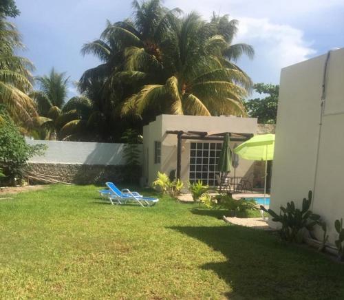 a yard with two lounge chairs and a house at CASA KINICH SISAL in Sisal