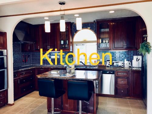 a kitchen with a kdefinition sign on the wall at ペンション ラナカイハウス沖縄 in Onna
