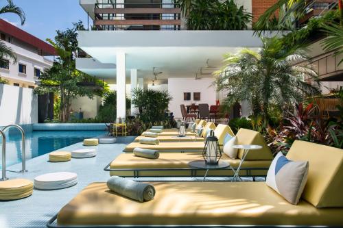 a row of lounge chairs and a swimming pool at Viroth's Villa in Siem Reap