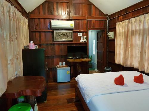 una camera da letto con un letto con cuscini rossi di Greenhouse resort a Buriram